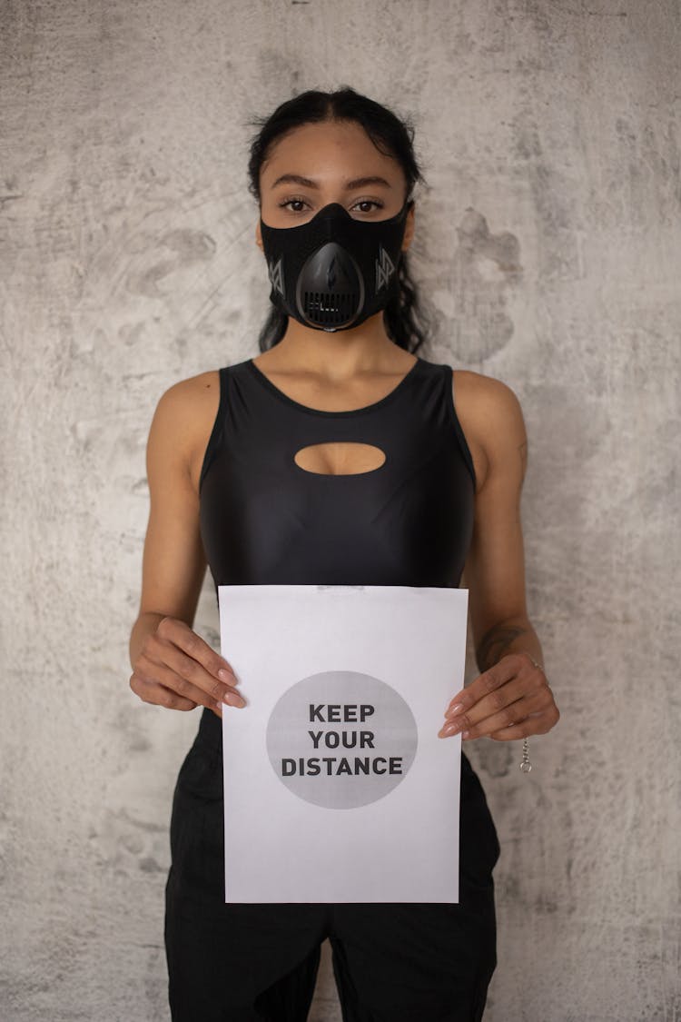 Black Woman In Respiratory Mask Showing Inscription On Paper