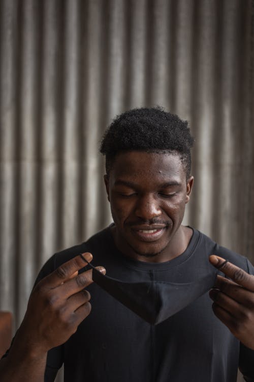 Black man putting on protective mask