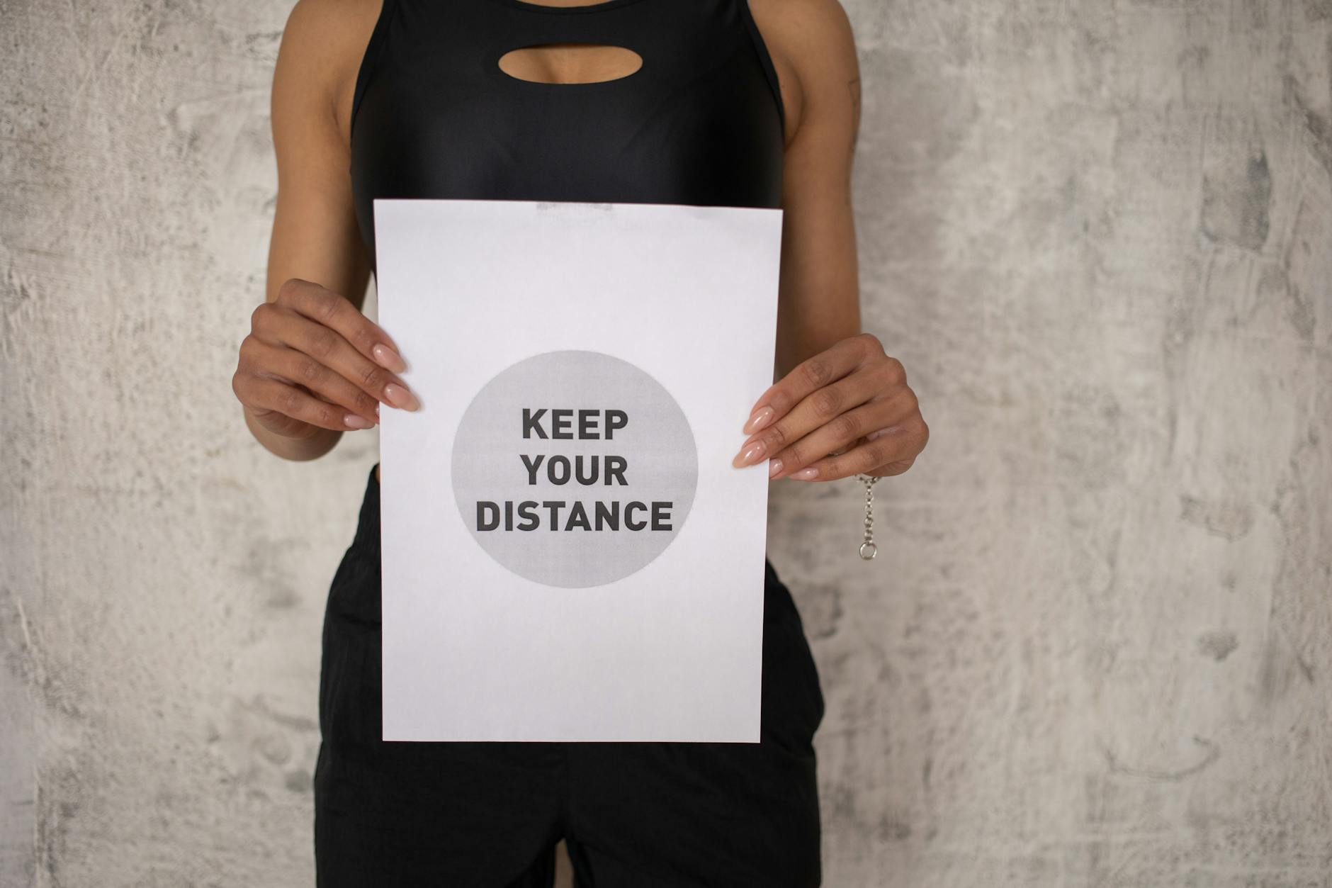 Black woman showing paper with inscription for keeping social distance