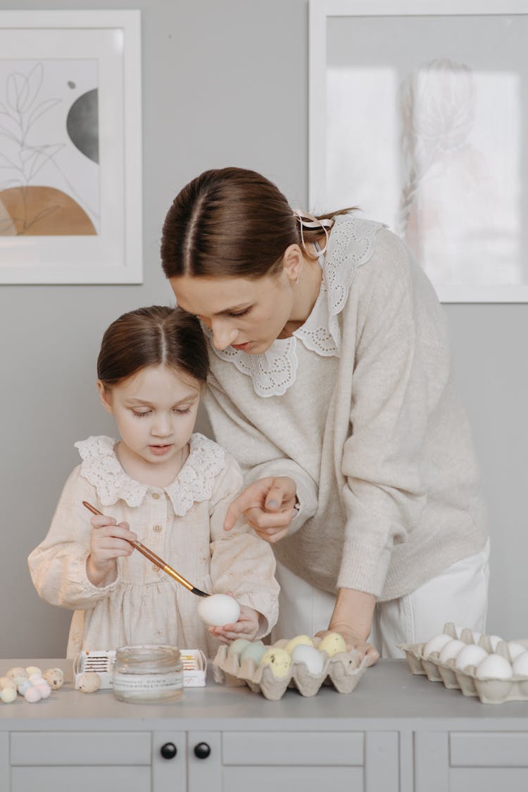 Woman And Child Painting The Eggs