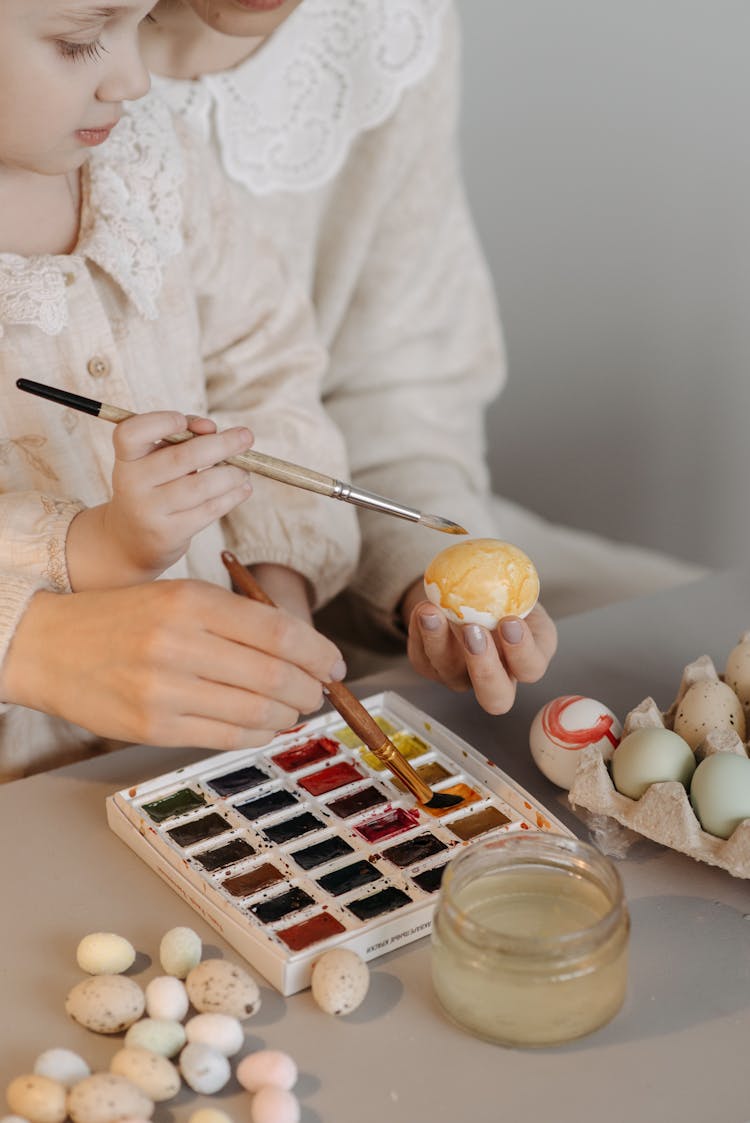 A Child Painting An Easter Egg