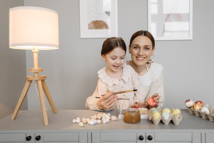 A Mother Painting Easter Eggs With Her Daughter