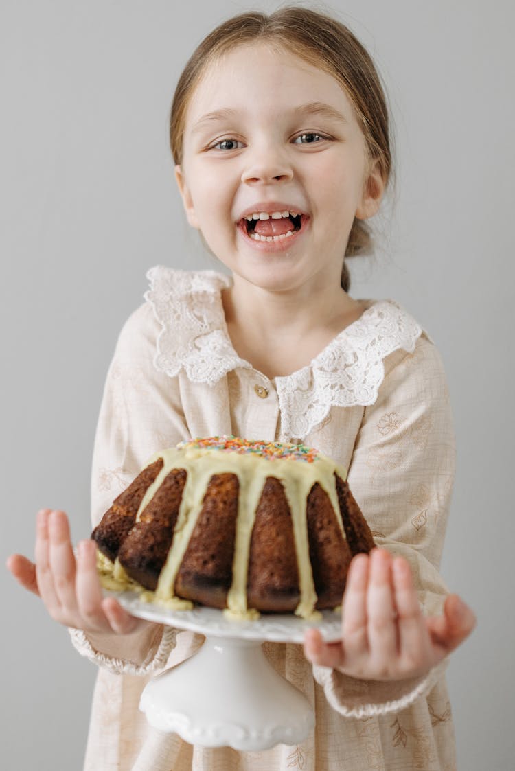 A Cheerful Girl Holding A Cake