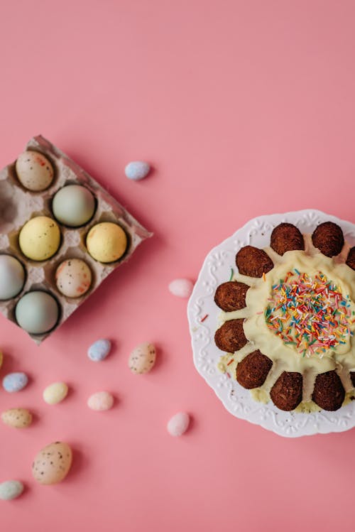 Flat Lay Photography of Easter Eggs and Cake on Pink Surface