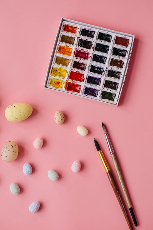 A Palette of Water Color Beside  Eggs and Brushes