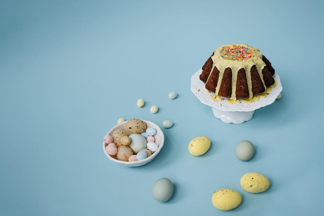 Free Chocolate Cake with Sprinkles and Easter Eggs on Blue Background Stock Photo