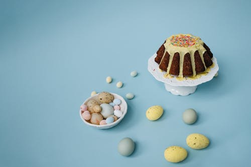Free Chocolate Cake with Sprinkles and Easter Eggs on Blue Background Stock Photo