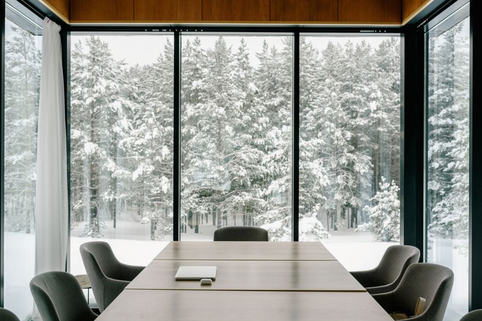 Elegant conference room featuring large windows with a snowy forest view, perfect for serene business meetings.