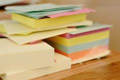 Vibrant stack of colorful sticky notes, neatly arranged on a wooden table.
