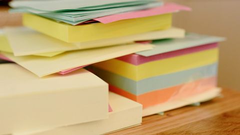 Vibrant stack of colorful sticky notes, neatly arranged on a wooden table.