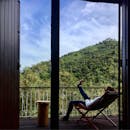 一名女子在阳台上俯瞰巴西郁郁葱葱的山脉，享受着宁静的时刻
