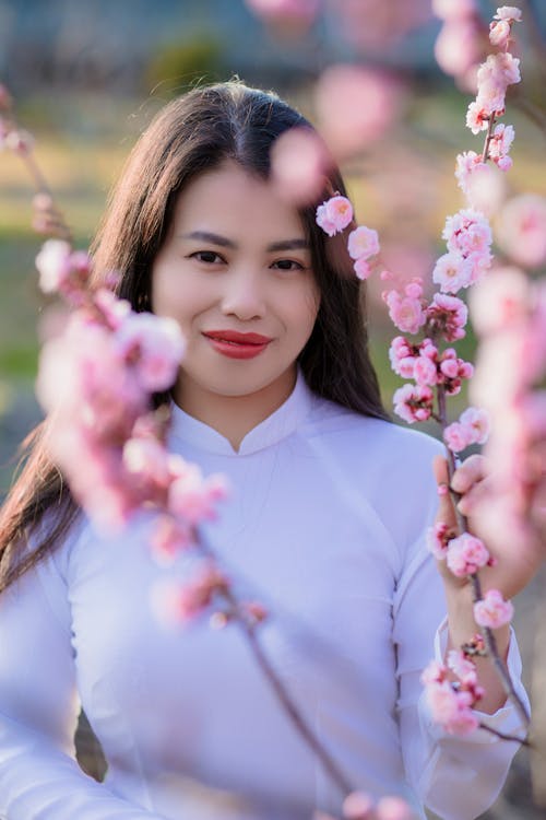 Woman in White Dress Near Cherry Blossoms