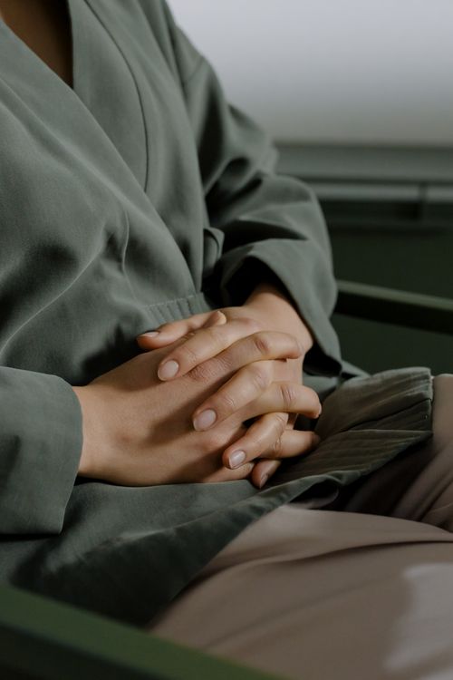 Free Close-up of hands resting in a stylish green robe, highlighting calm and relaxation. Stock Photo