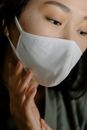 Woman in White Tank Top Covering Her Face With White Textile