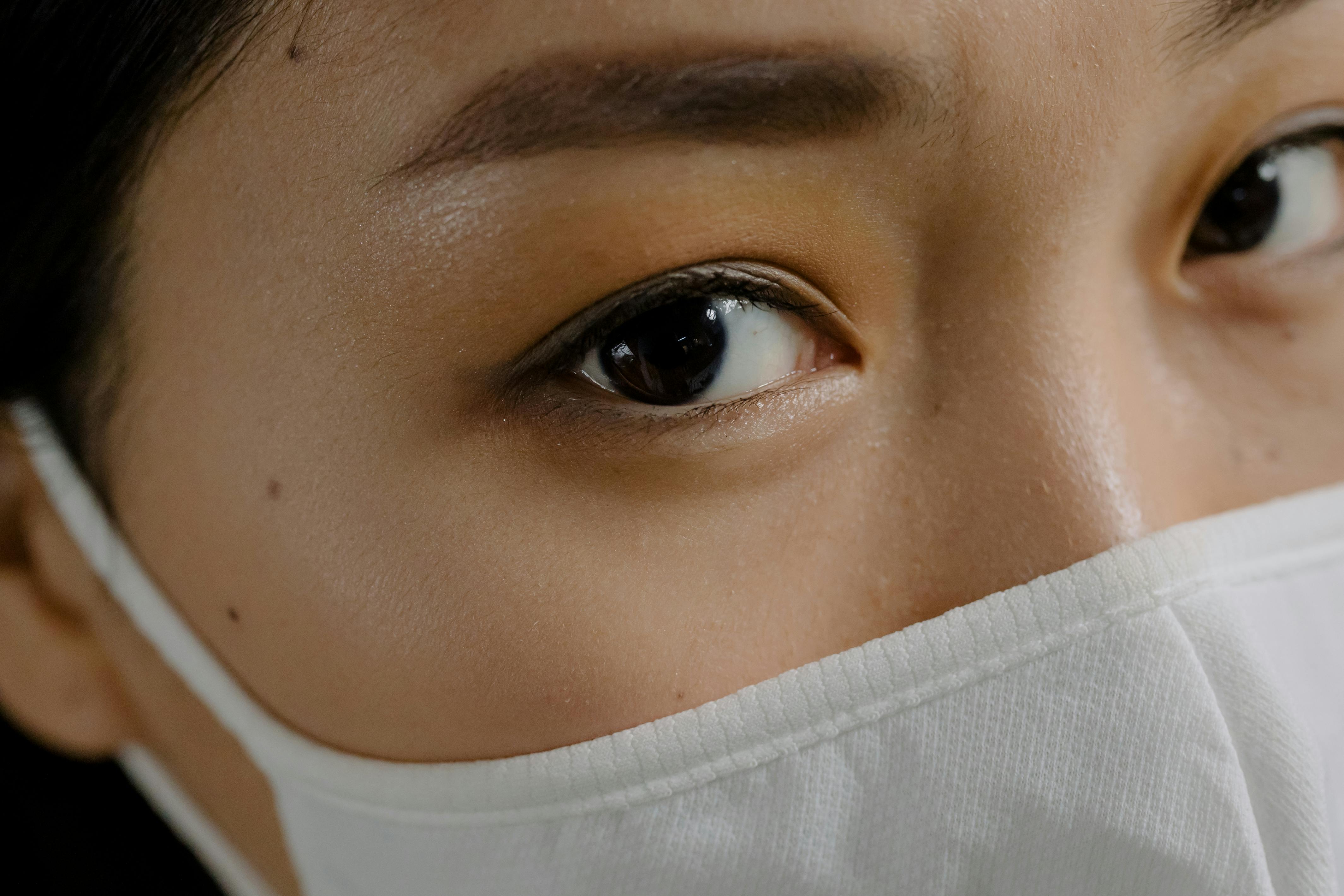 crop woman with brown eyes in mask