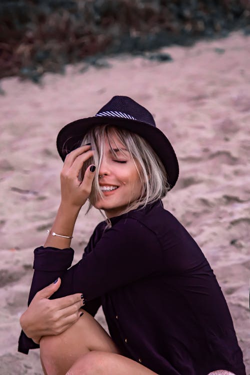 Woman Wearing Long Sleeve Shirt Sitting on Sand