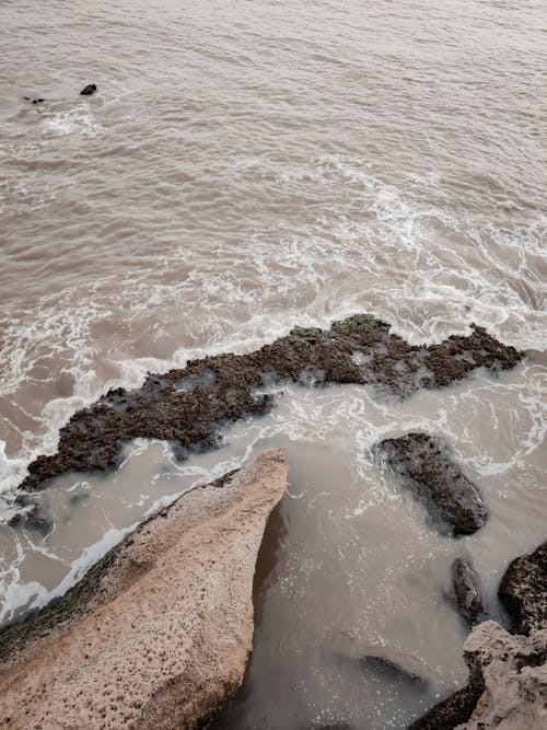 Rippling sea splashing near rocky shore