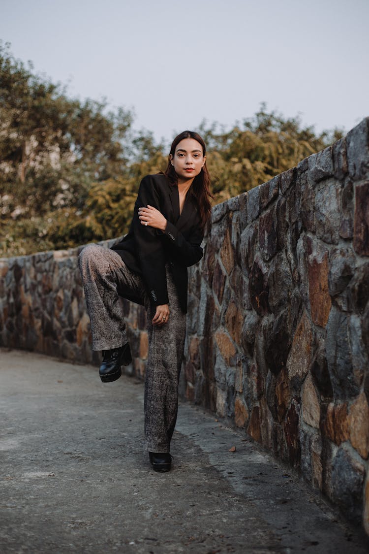 Stylish Woman Standing With One Leg Bent On Knee