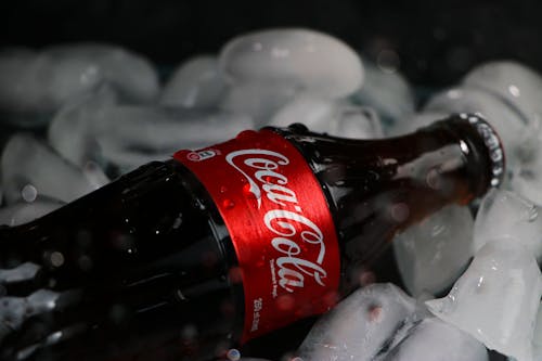 A Close-Up Shot of a Coca Cola Bottle on Ice