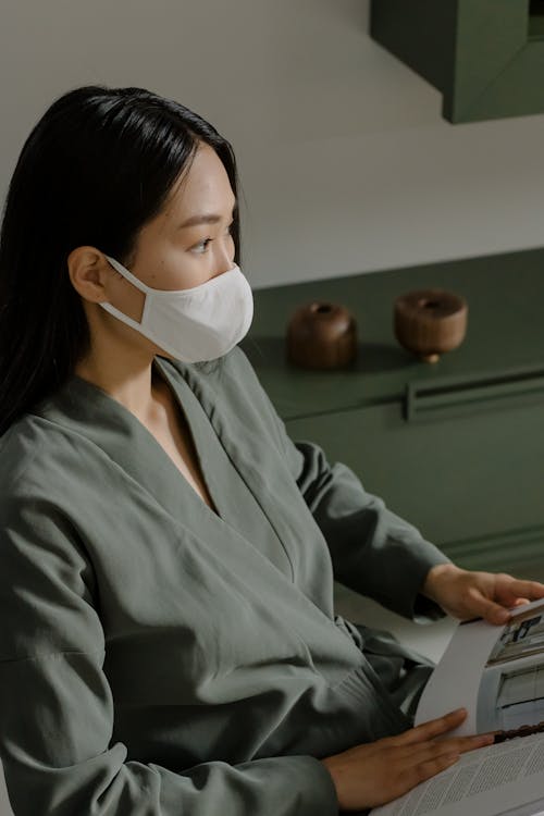 Woman in Gray Long Sleeves Wearing a White Face Mask