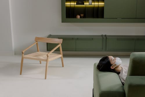 Person Lying on a Pastel Green Couch