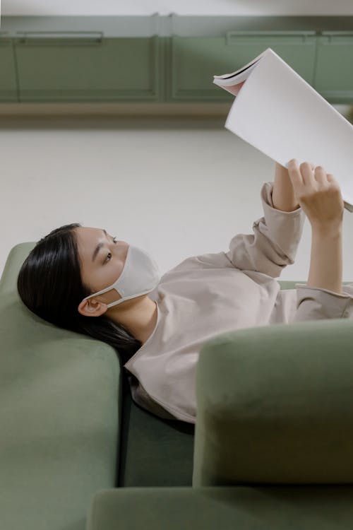 Woman Lying on a Couch Reading a Book 