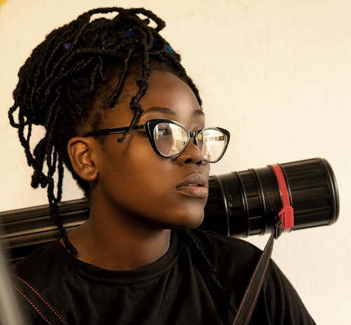 Girl with Braided Hairstyle Wearing Eyeglasses and Holding a Protective Tube for Drawings