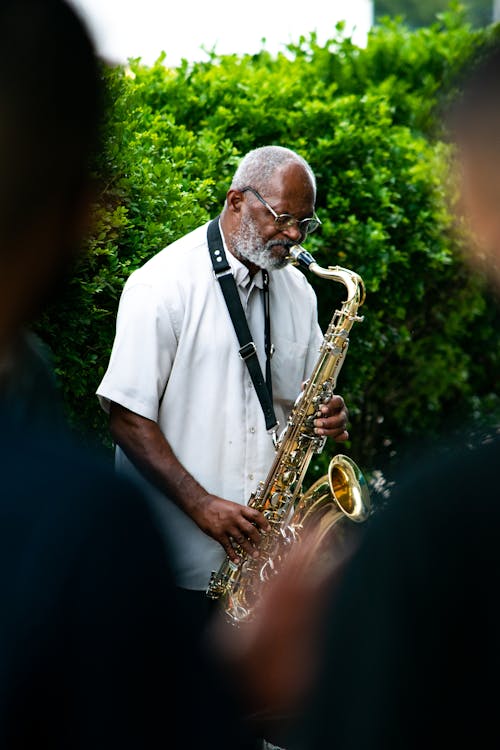 Man in White Button Up Shirt Playing Saxophone