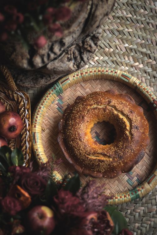 Free Close-up of round baked bread on a woven tray surrounded by rustic elements and apples. Stock Photo