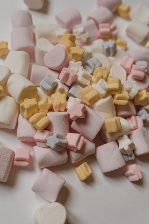 Sweet colorful marshmallows heaped on white table