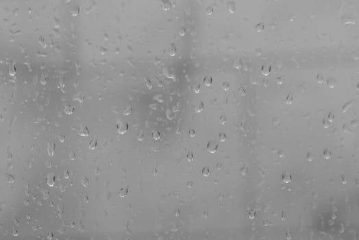 Full frame through window glass covered with water drops on rainy gloomy weather