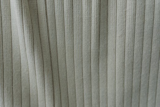Close-up of a green cotton fabric with ribbed vertical stripes, showcasing texture and pattern.
