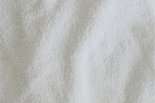 Free Top view full frame of soft white towel fabric placed on table in light room Stock Photo