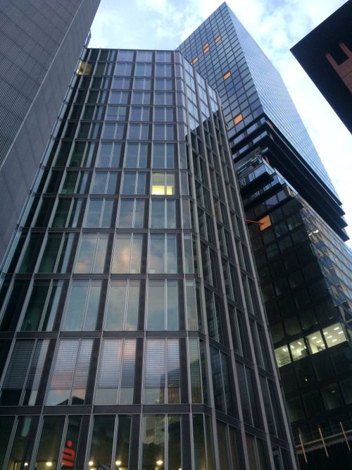 Free Low angle view of modern skyscrapers with glass facades reflecting the evening sky. Stock Photo