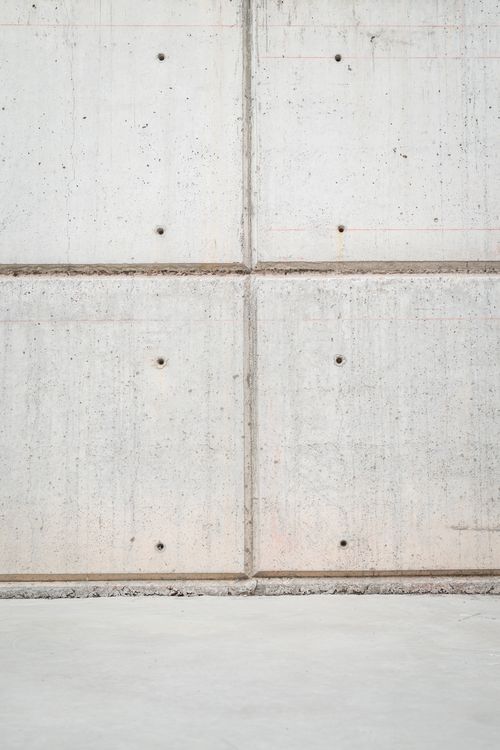 Free A minimalist photo of a concrete wall showing texture and pattern with visible holes. Stock Photo