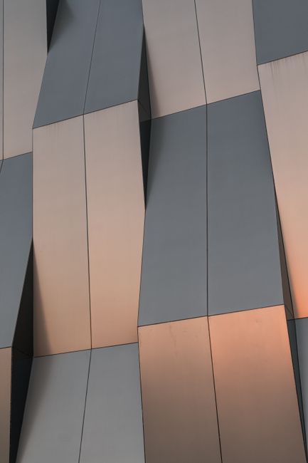 A close-up of a modern building facade with geometric and metallic design elements.