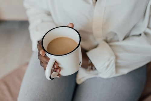 Free Close-up of a person holding a ceramic mug with coffee, representing a cozy morning routine. Stock Photo