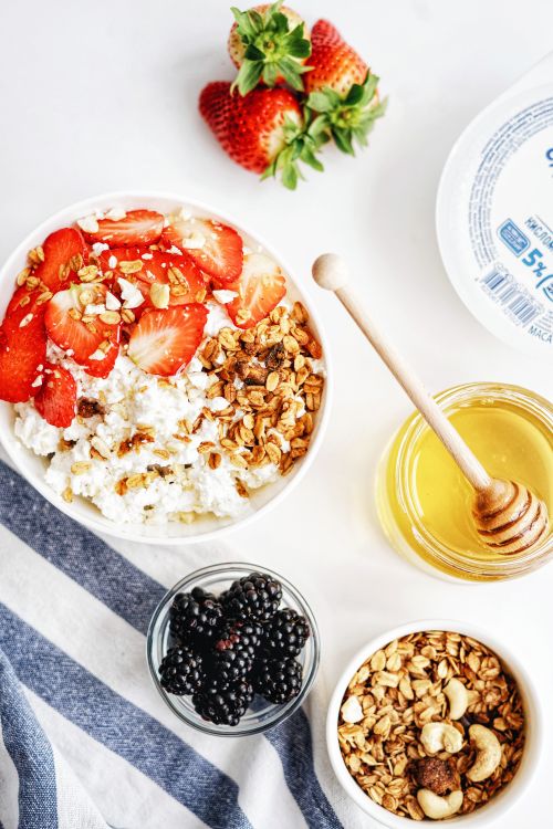 Free Top view of a breakfast bowl with strawberries, granola, ricotta, and honey for a nutritious morning. Stock Photo