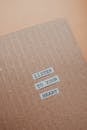 Paper Cut Outs with Texts on the Brown Cardboard