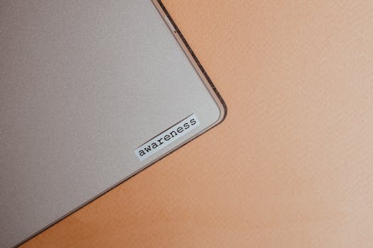 Close-up of a beige laptop with an awareness sticker, promoting mindfulness and digital organization.