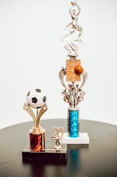 Close-up of soccer and basketball trophies celebrating sports success.