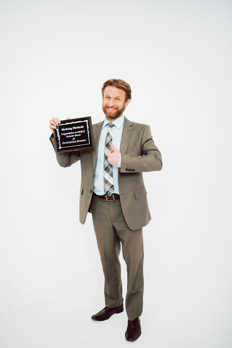 A Man In Gray Suit Holding A Plaque