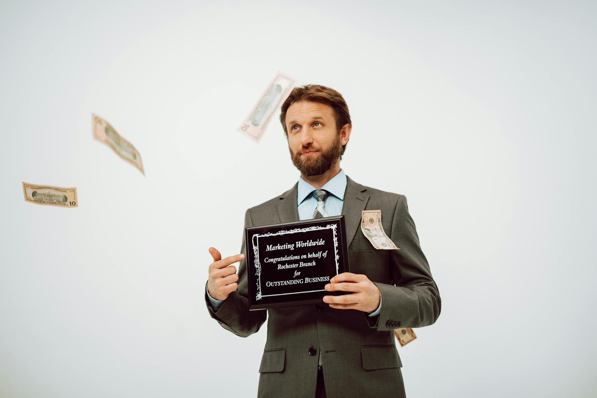 A Man in the Business Suit Holding a Black Plaque