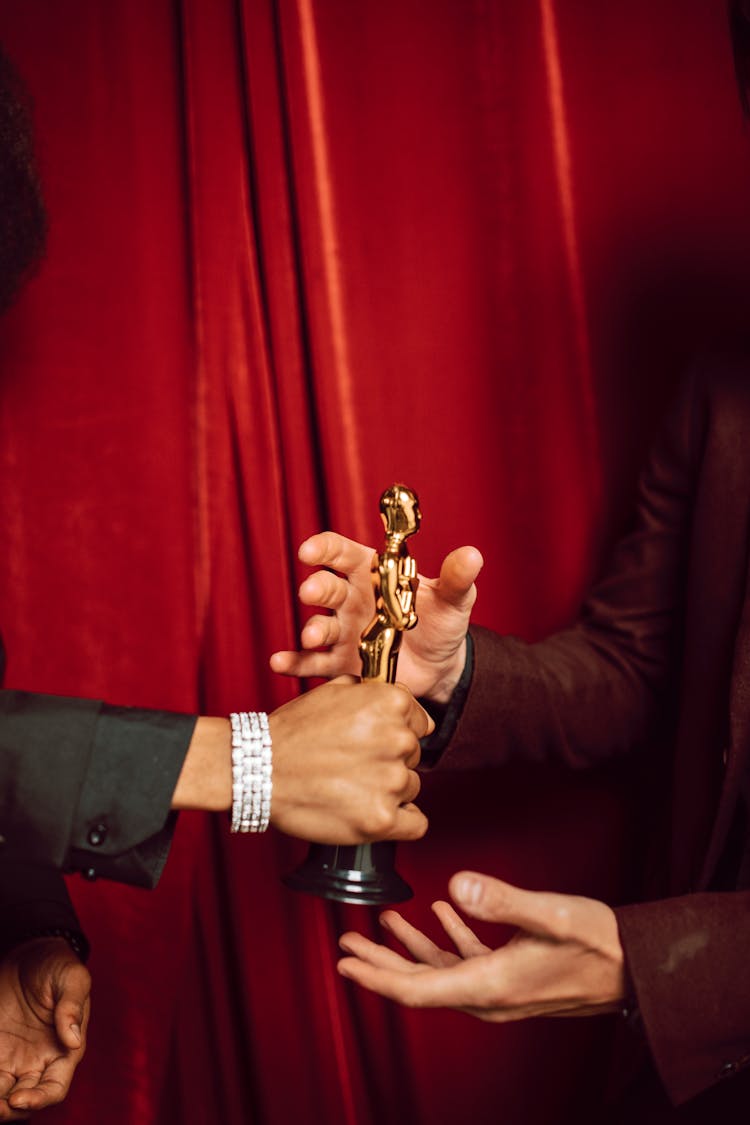 Hands Of A Man Receiving A Gold Trophy