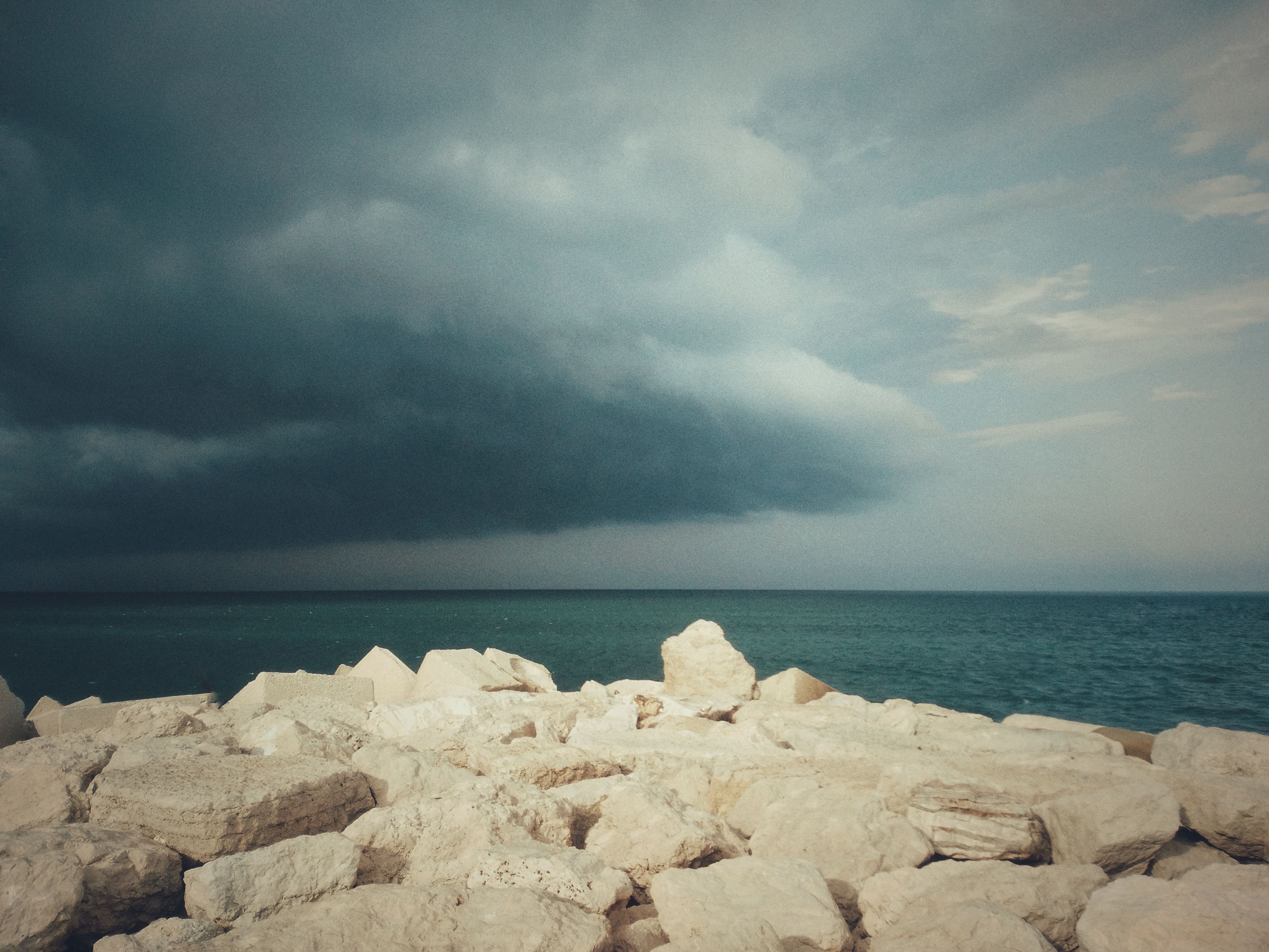 Stormy sky over rocky seashore in Ancona, Italy, capturing a dramatic coastal scene.
