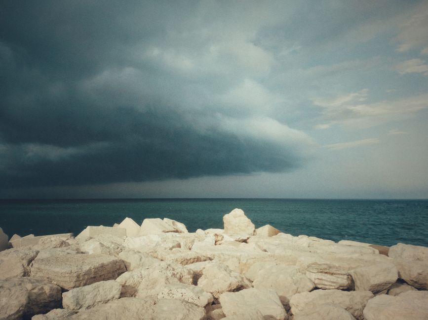 Stormy sky over rocky seashore in Ancona, Italy, capturing a dramatic coastal scene.