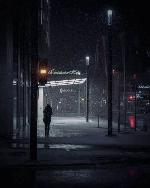Silhouette of a Person Walking in the Rain at Night