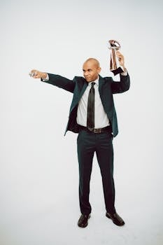 Confident businessman in a suit celebrates an award victory in a studio setting.