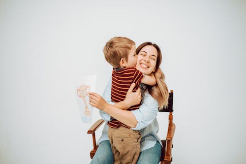 A Boy Hugging and Kissing His Mother 