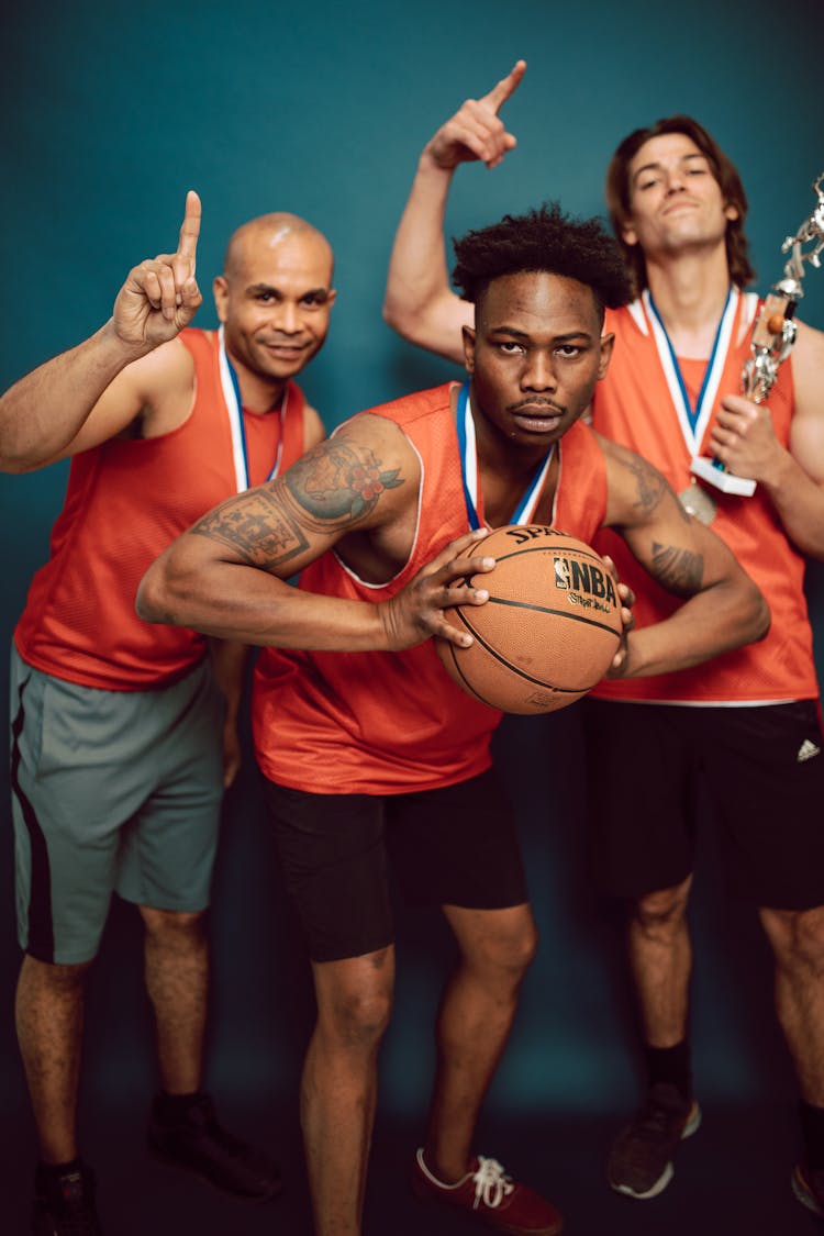 Basketball Players Wearing Uniform Holding Ball And Trophy